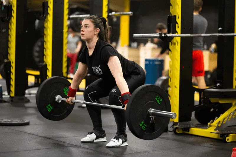 A woman working out using a barbell